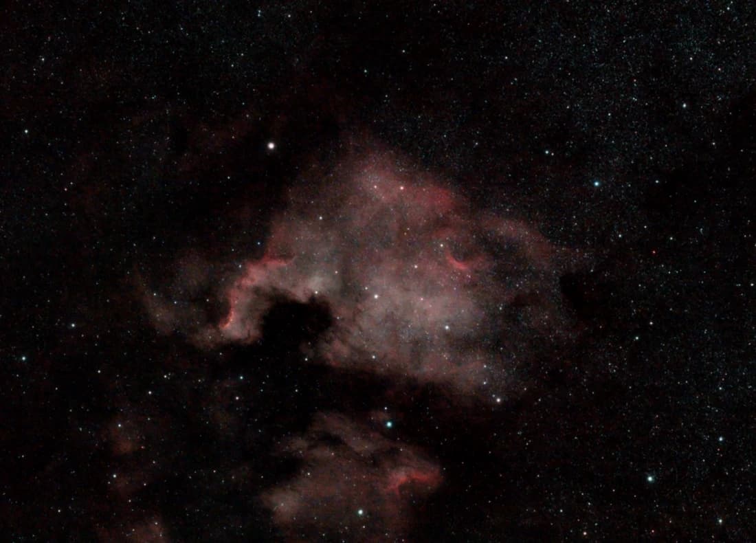 Red clouds of the North America Nebula surrounded by a dense field of stars